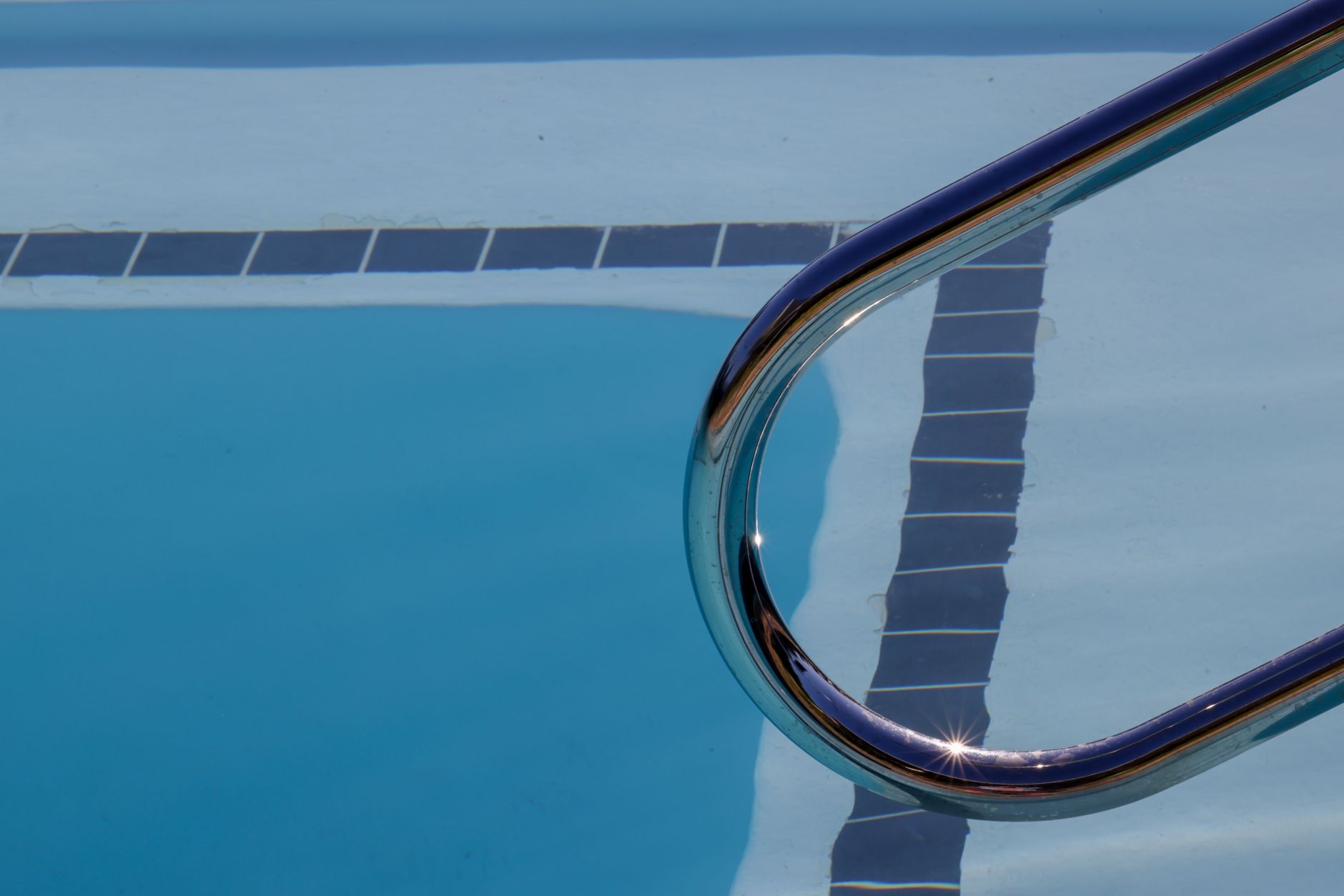 A pristine newly resurfaced pool in an Arizona backyard with desert landscaping, showing the smooth plaster finish