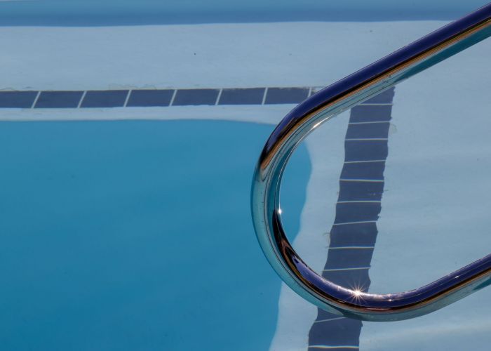 A pristine newly resurfaced pool in an Arizona backyard with desert landscaping, showing the smooth plaster finish